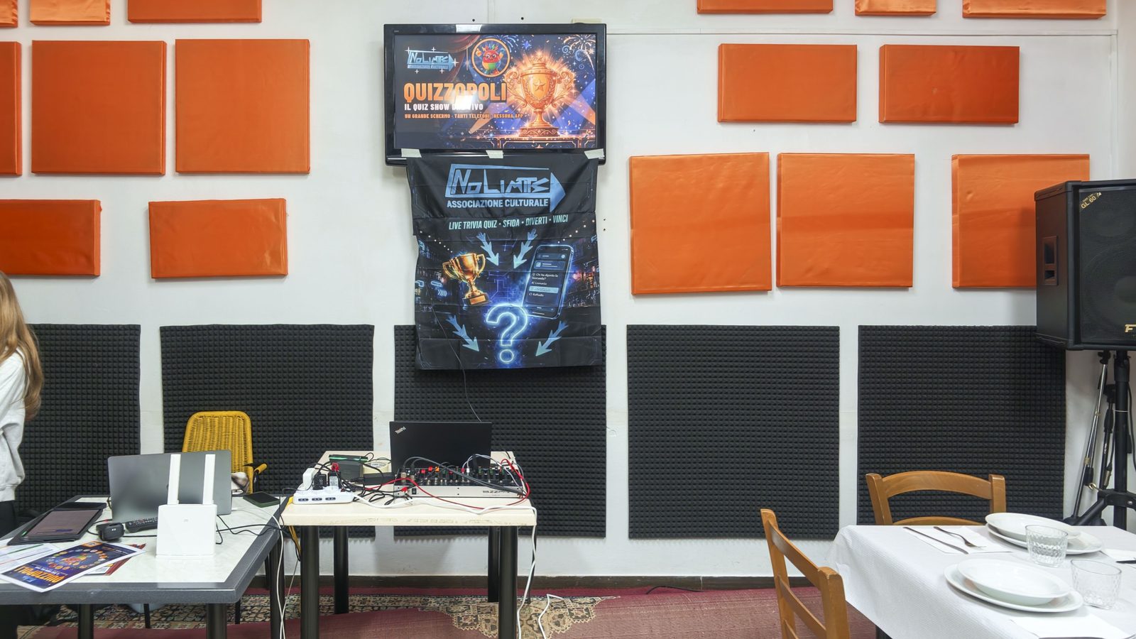 Schermo con la schermata di Quizzopoli e striscione No Limits nella sala del Circolo Gori durante la serata del 24 ottobre 2026